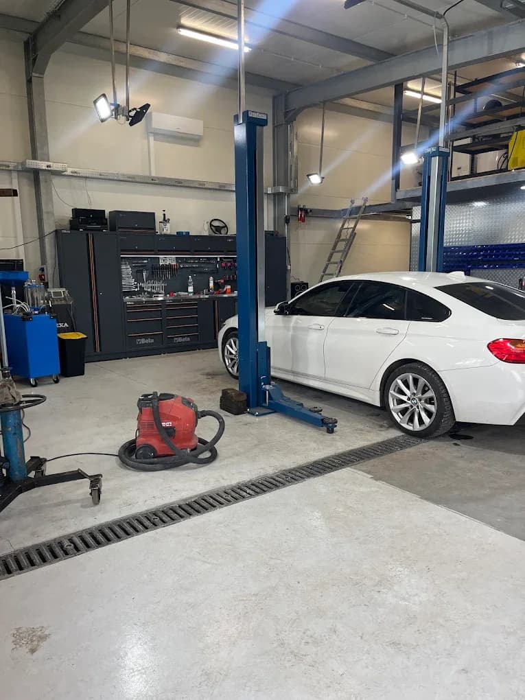 Warsztat stacjonarny Kraków, samochód osobowy BMW na dwukolumnowym podnośniku podczas wymiany opon i wulkanizacji